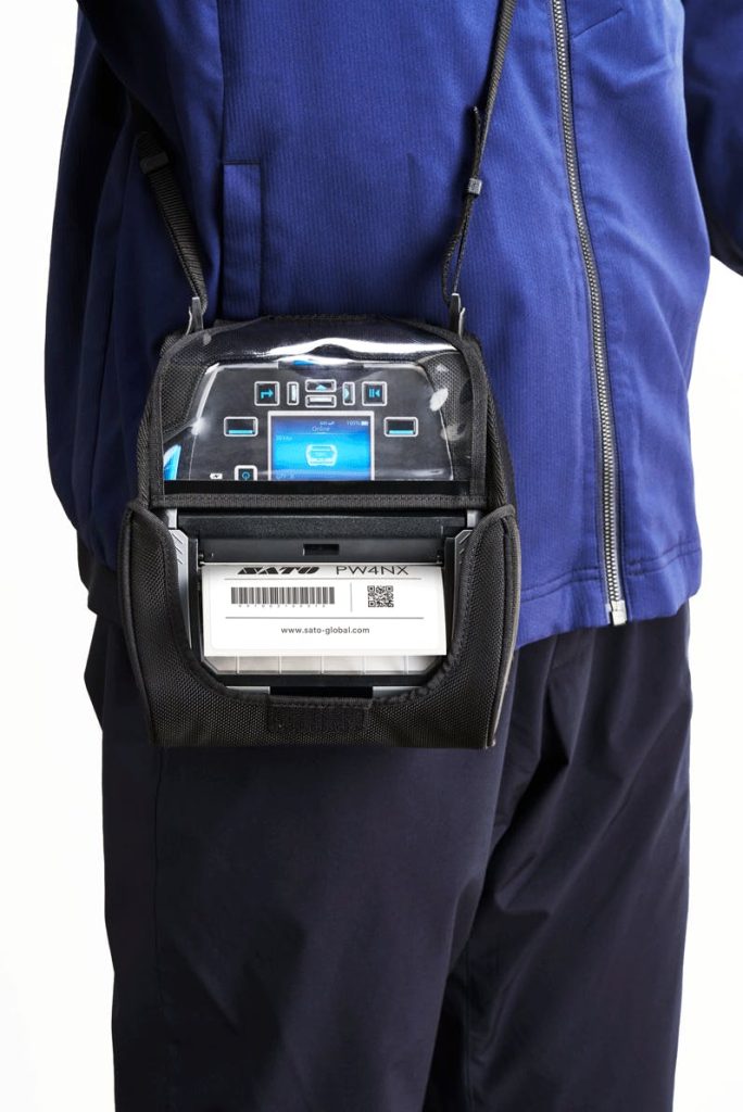 Worker wearing portable label printer in carrying case.